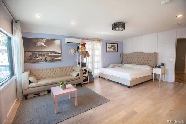 a large bed sitting in a bedroom next to a window and chandelier