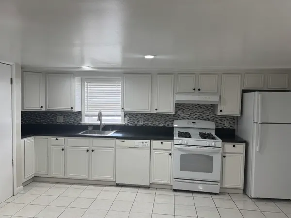 a kitchen with white cabinets sink and white appliances