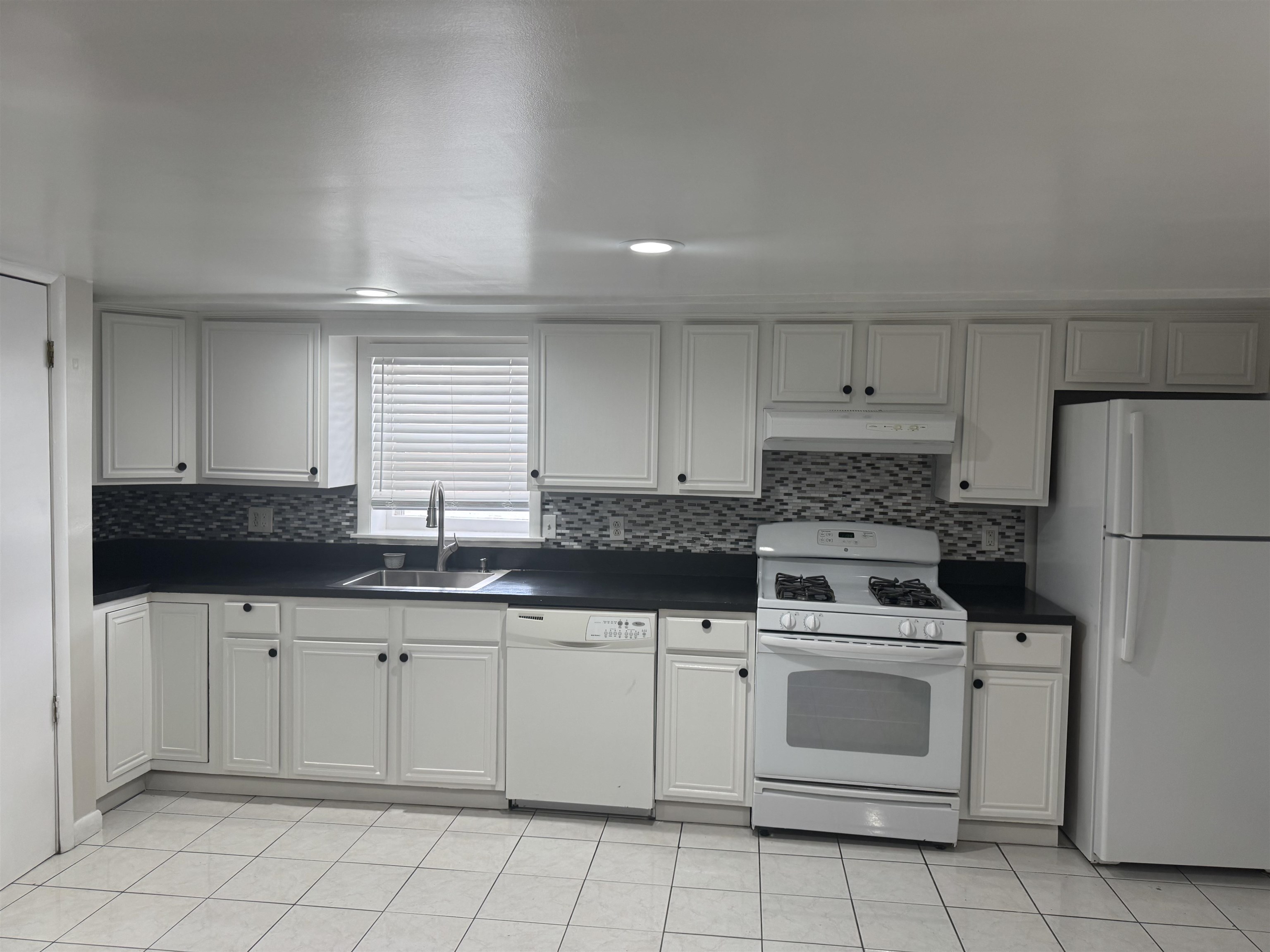 171 Charles Street, Unit 2 Secaucus, NJ 07094 - Photo 2 of 11 a kitchen with white cabinets sink and white appliances