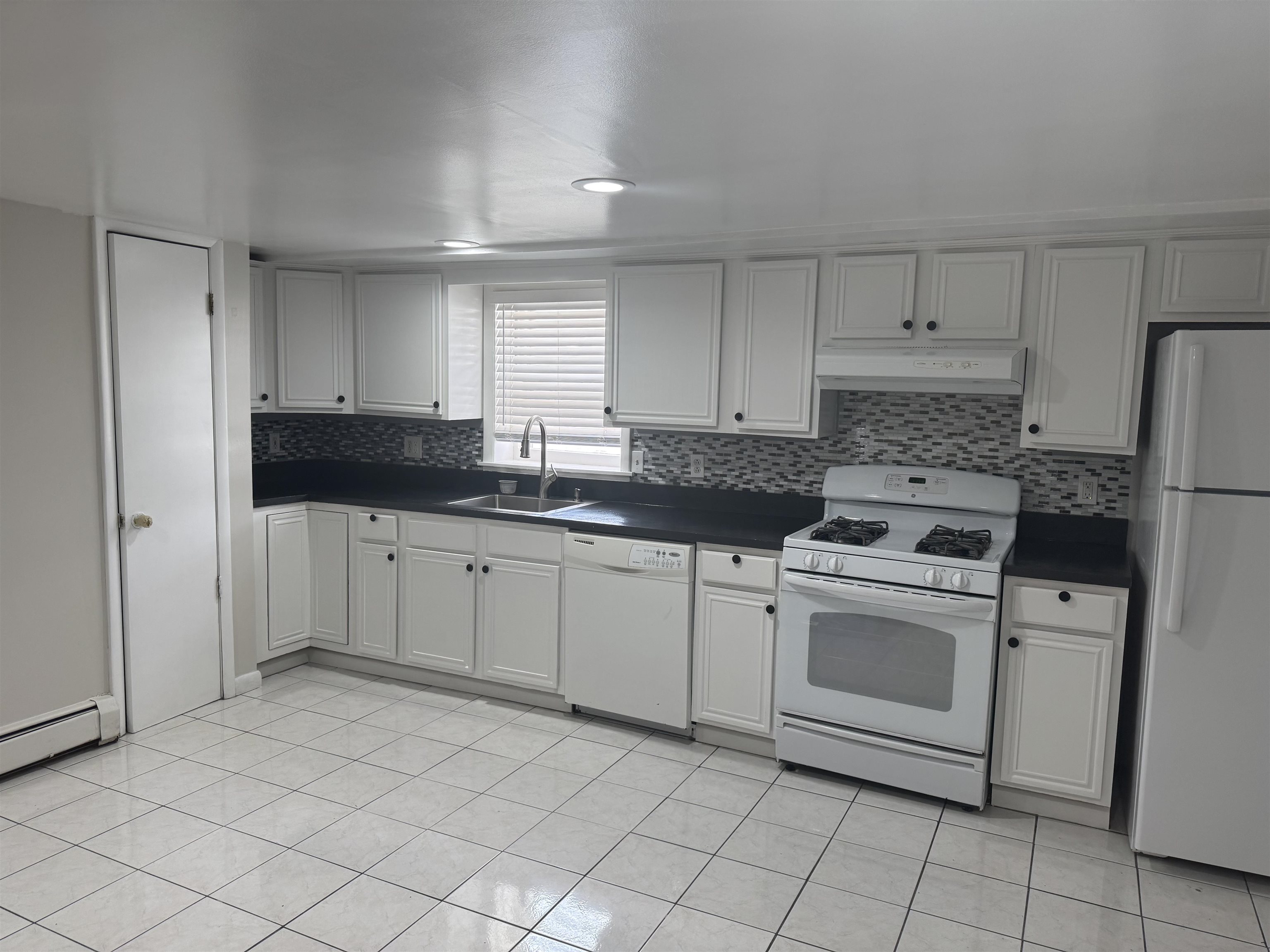 171 Charles Street, Unit 2 Secaucus, NJ 07094 - Photo 3 of 11 a kitchen with granite countertop white cabinets and white appliances