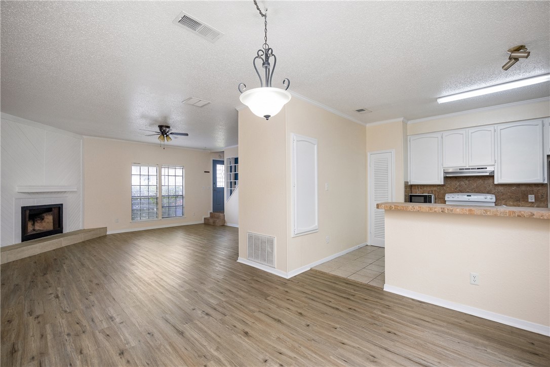 3052 Quail Springs Road, Unit A2 Corpus Christi, TX 78414 - Photo 11 of 31 a view of a kitchen with wooden floor and a ceiling fan