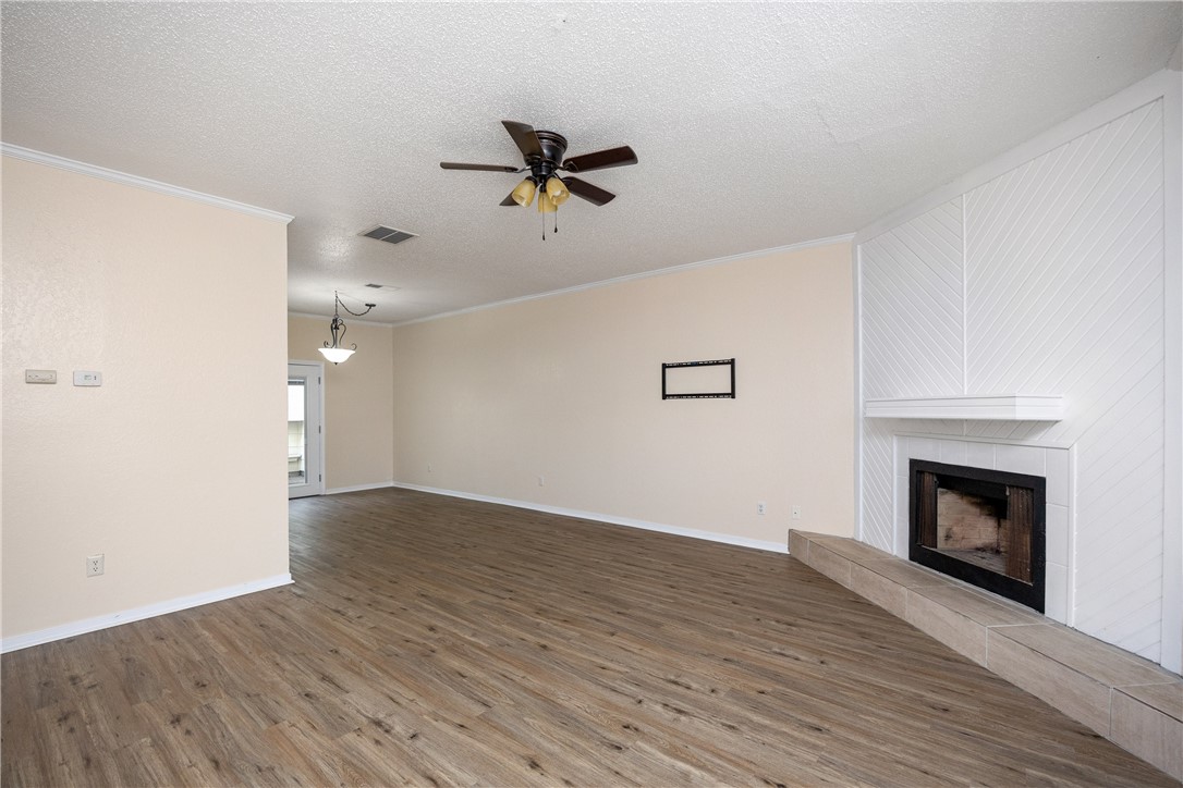 3052 Quail Springs Road, Unit A2 Corpus Christi, TX 78414 - Photo 13 of 31 an empty room with wooden floor fireplace and windows