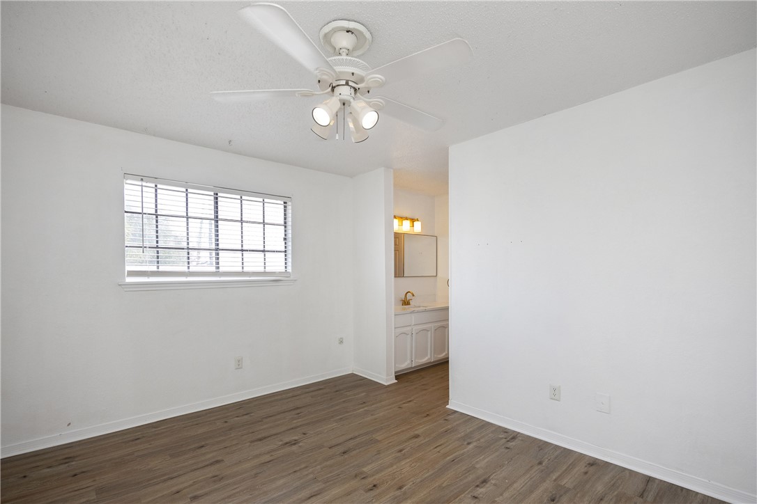 3052 Quail Springs Road, Unit A2 Corpus Christi, TX 78414 - Photo 20 of 31 an empty room with wooden floor and windows