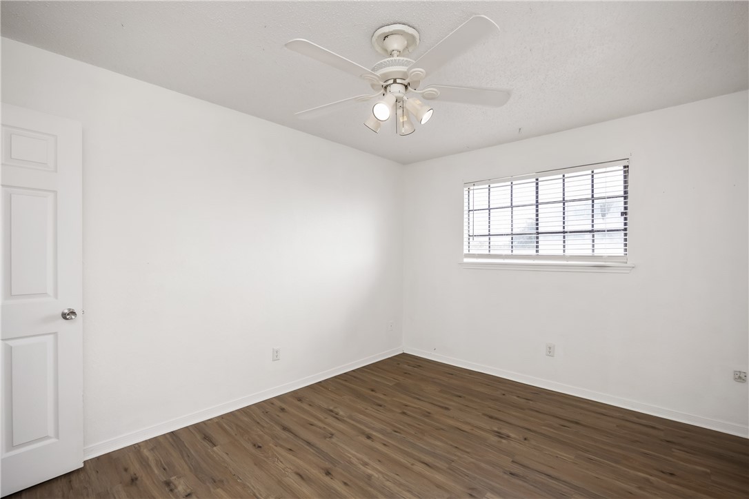 3052 Quail Springs Road, Unit A2 Corpus Christi, TX 78414 - Photo 21 of 31 wooden floor in an empty room with a window