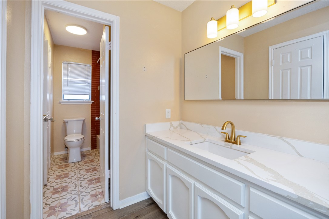 3052 Quail Springs Road, Unit A2 Corpus Christi, TX 78414 - Photo 25 of 31 a bathroom with a sink a toilet and a mirror