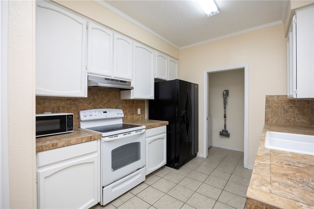 3052 Quail Springs Road, Unit A2 Corpus Christi, TX 78414 - Photo 4 of 31 a kitchen with a stove top oven and refrigerator