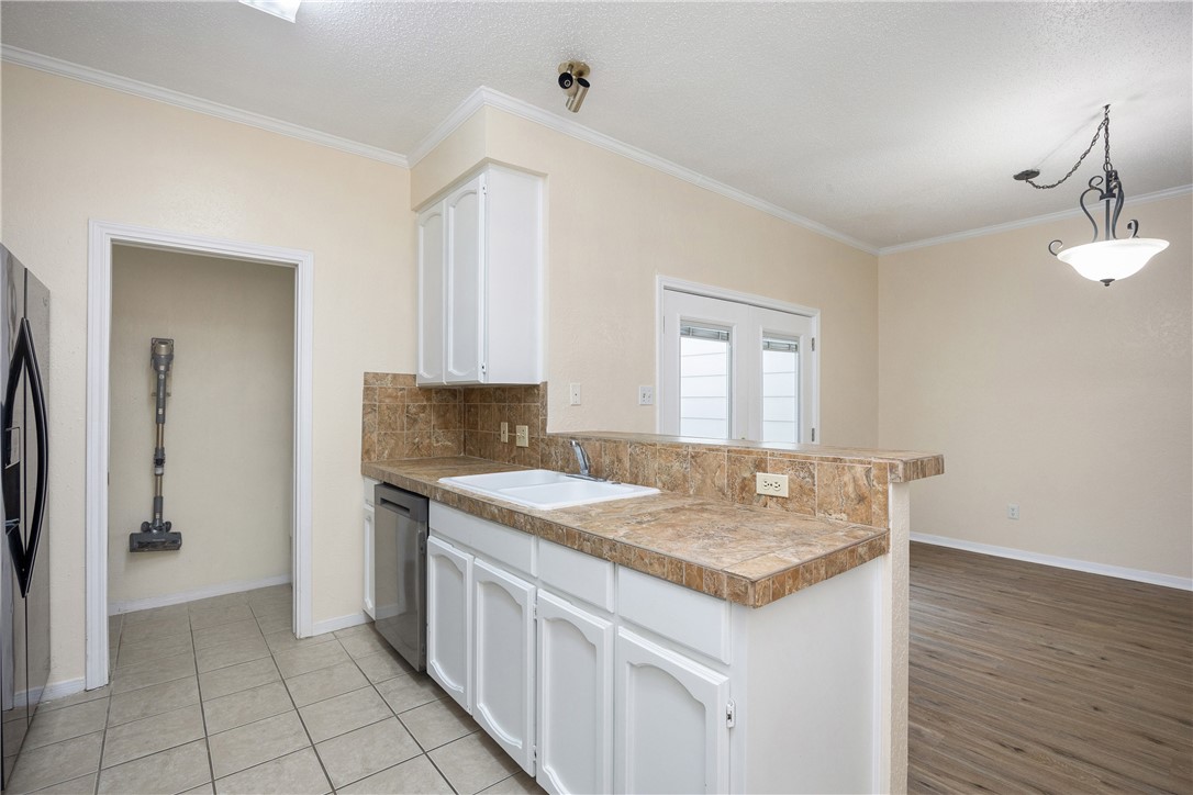 3052 Quail Springs Road, Unit A2 Corpus Christi, TX 78414 - Photo 5 of 31 a kitchen with granite countertop a sink stove and refrigerator