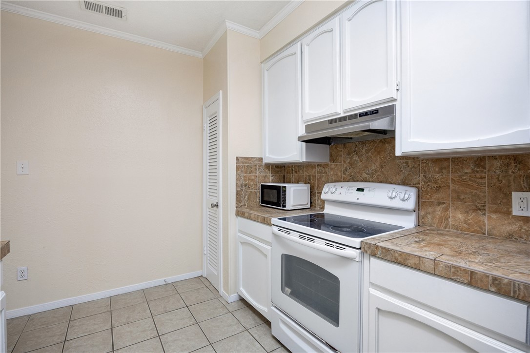 3052 Quail Springs Road, Unit A2 Corpus Christi, TX 78414 - Photo 6 of 31 a kitchen with white cabinets and white appliances