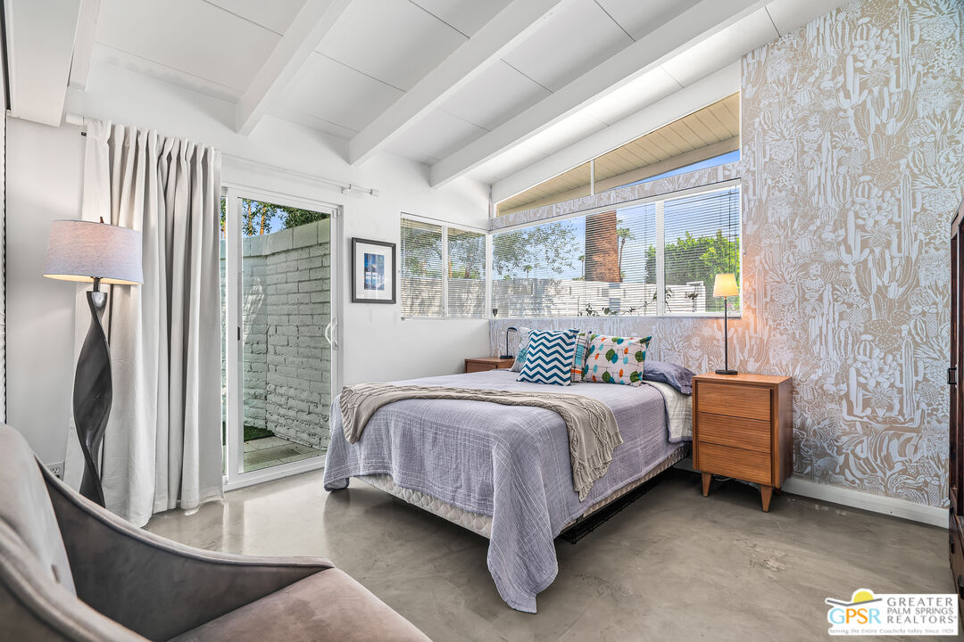 1655 Tamarisk Road Palm Springs, CA 92262 - Photo 20 of 39 a bedroom with a bed lamp and a large window