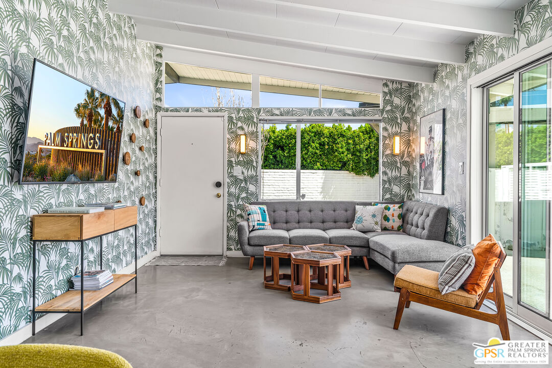 1655 Tamarisk Road Palm Springs, CA 92262 - Photo 9 of 39 a living room with furniture and a floor to ceiling window