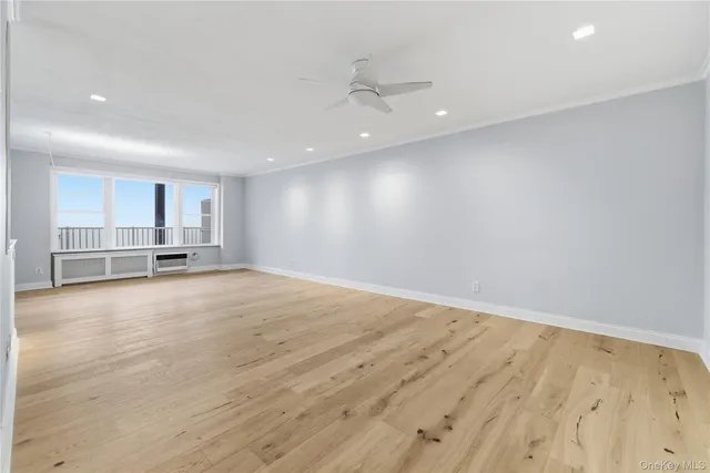 a view of empty room with wooden floor and window