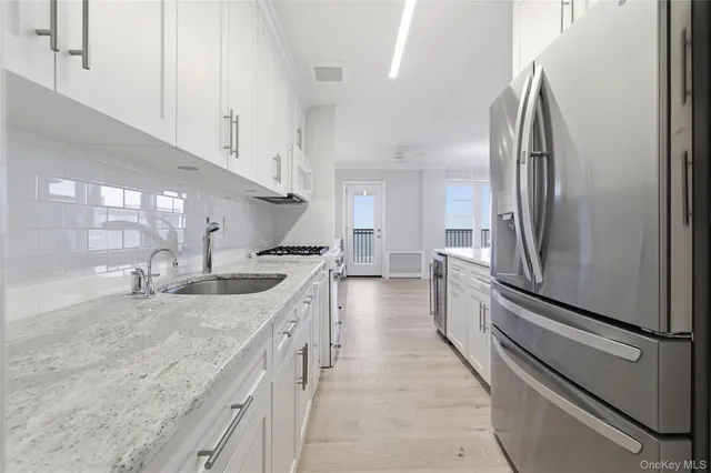 a kitchen with stainless steel appliances granite countertop a refrigerator and a sink