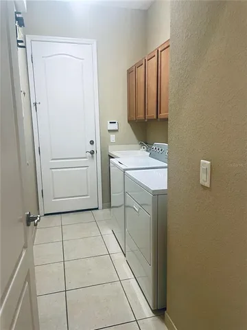 a utility room with cabinets washer and dryer