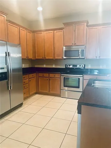 a kitchen with stainless steel appliances granite countertop a stove a sink and a refrigerator