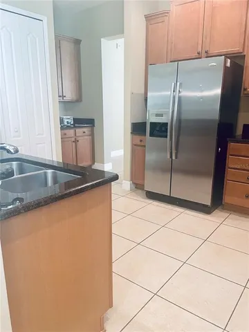 a kitchen with granite countertop a refrigerator and a sink