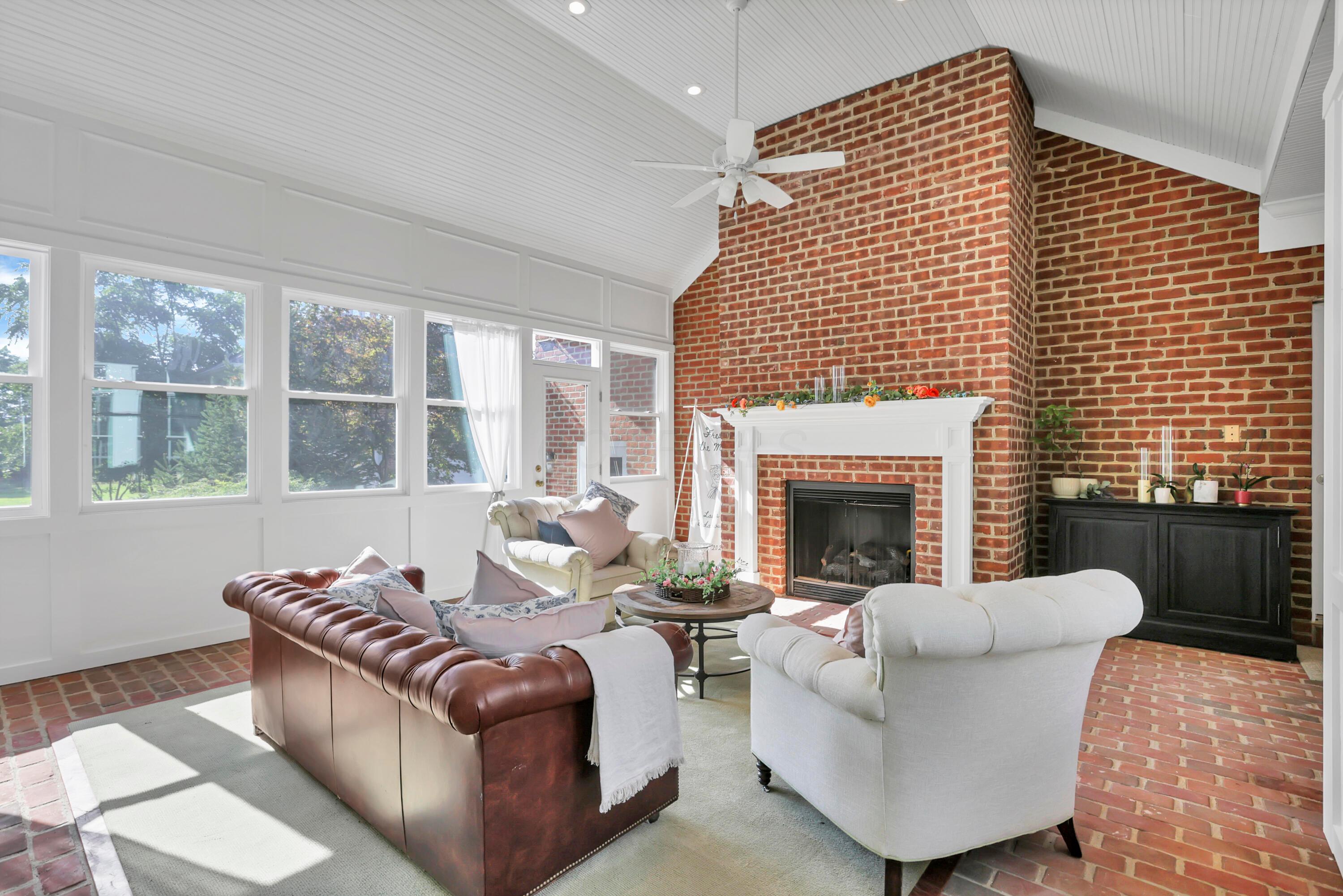 3575 State Rte 37 West Delaware, OH 43015 - Photo 47 of 106 Sunroom featuring a brick fireplace with a white mantel, vaulted beadboard ceiling, ceiling fan, and brick flooring