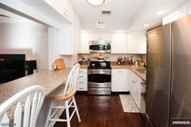11A South Maple Avenue, Unit B Park Ridge, NJ 07656 - Photo 6 of 16 a kitchen with stainless steel appliances a stove a sink and a refrigerator