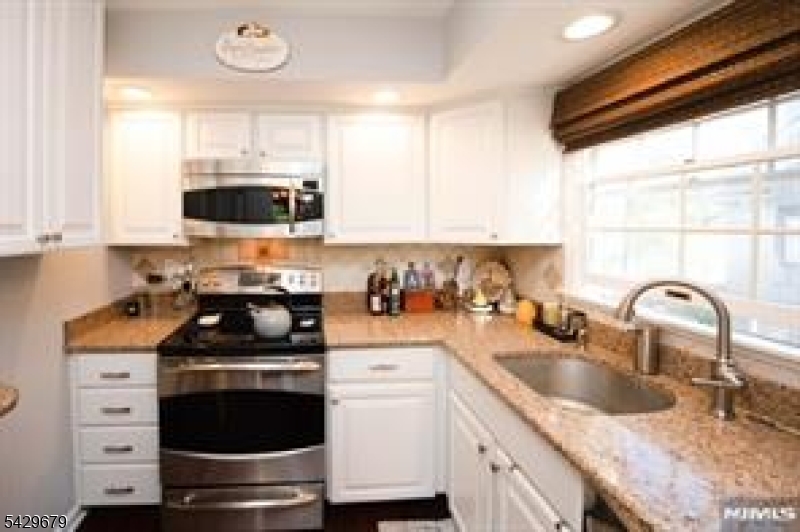 11A South Maple Avenue, Unit B Park Ridge, NJ 07656 - Photo 8 of 16 a kitchen with sink a microwave a stove and cabinets