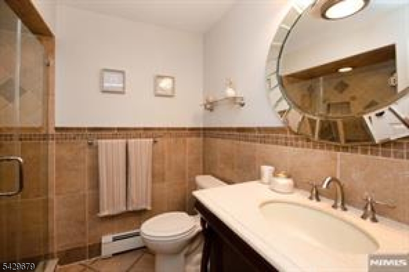 11A South Maple Avenue, Unit B Park Ridge, NJ 07656 - Photo 9 of 16 a bathroom with a sink mirror vanity and toilet