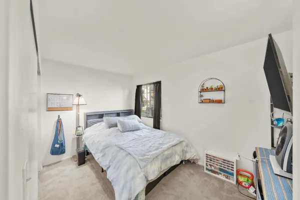a bedroom with a bed and a flat screen tv