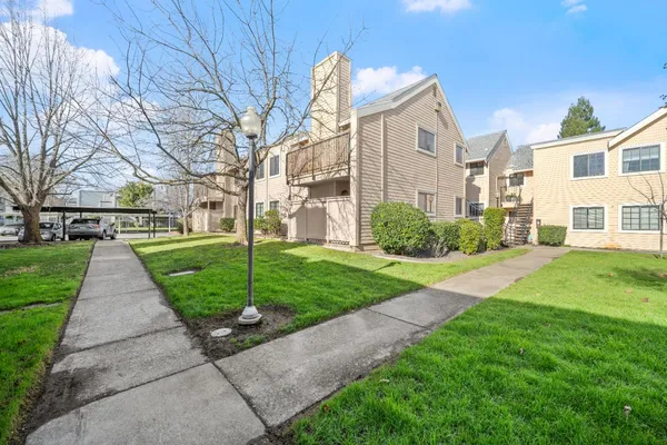 a front view of a house with a yard and trees