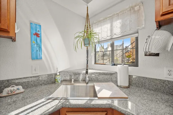 a kitchen with kitchen island granite countertop a sink and a window