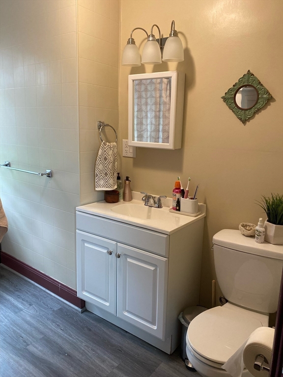 877 High Street Fall River, MA 02720 - Photo 12 of 26 a bathroom with a toilet sink vanity and mirror