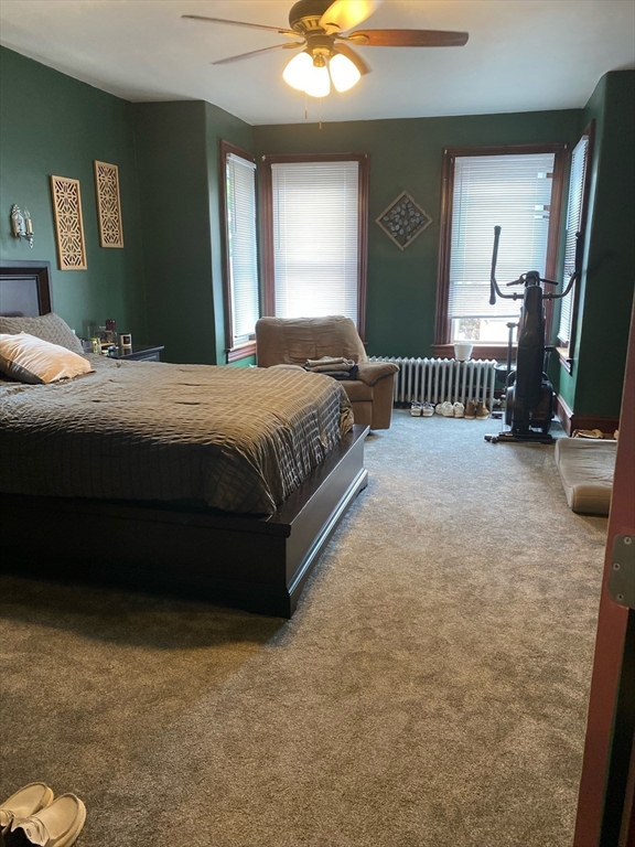 877 High Street Fall River, MA 02720 - Photo 9 of 26 a bedroom with a bed and a chandelier