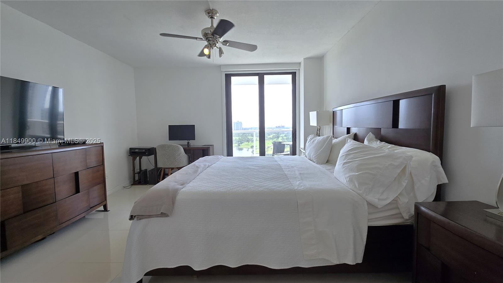 3731 North Country Club Drive, Unit 1825 Aventura, FL 33180 - Photo 14 of 25 a bedroom with a bed a dresser and flat screen tv