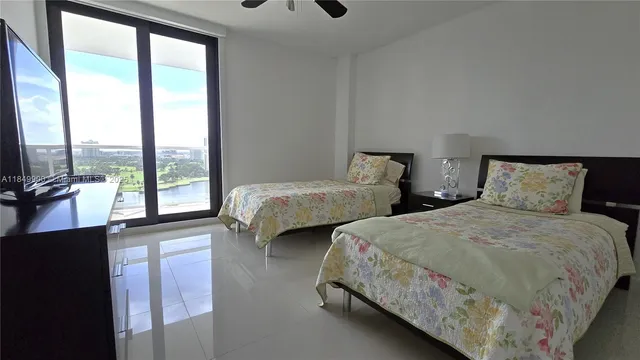 a bedroom with two beds and a large window