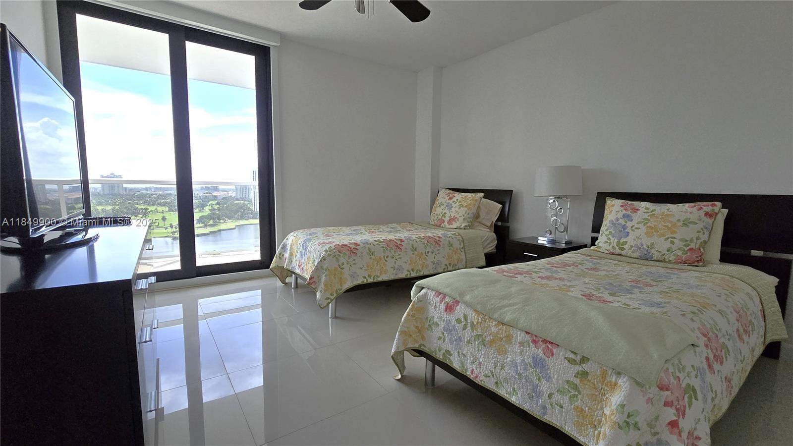 3731 North Country Club Drive, Unit 1825 Aventura, FL 33180 - Photo 19 of 25 a bedroom with two beds and a large window