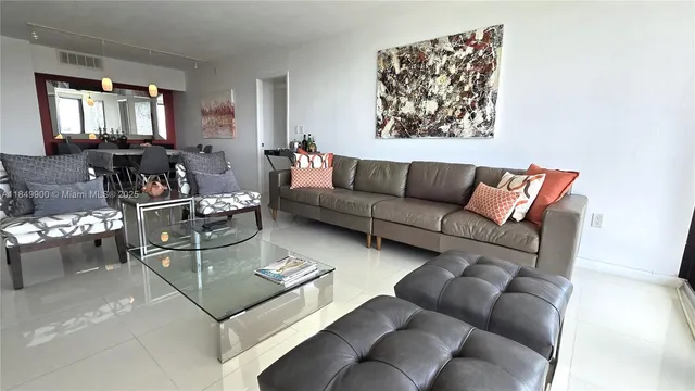 a living room with furniture a dining table and a painting