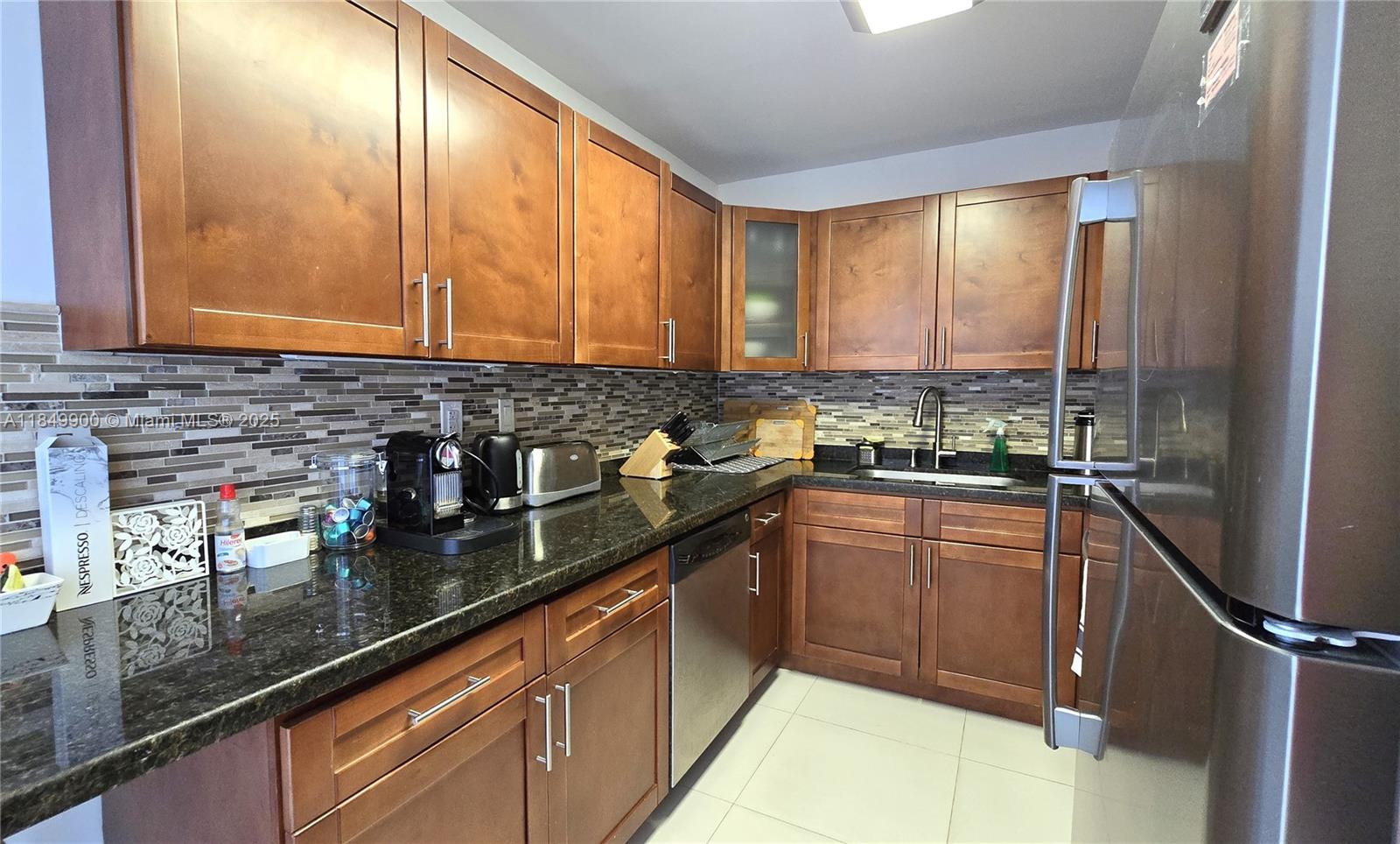 3731 North Country Club Drive, Unit 1825 Aventura, FL 33180 - Photo 6 of 25 a kitchen with stainless steel appliances granite countertop a sink stove and cabinets