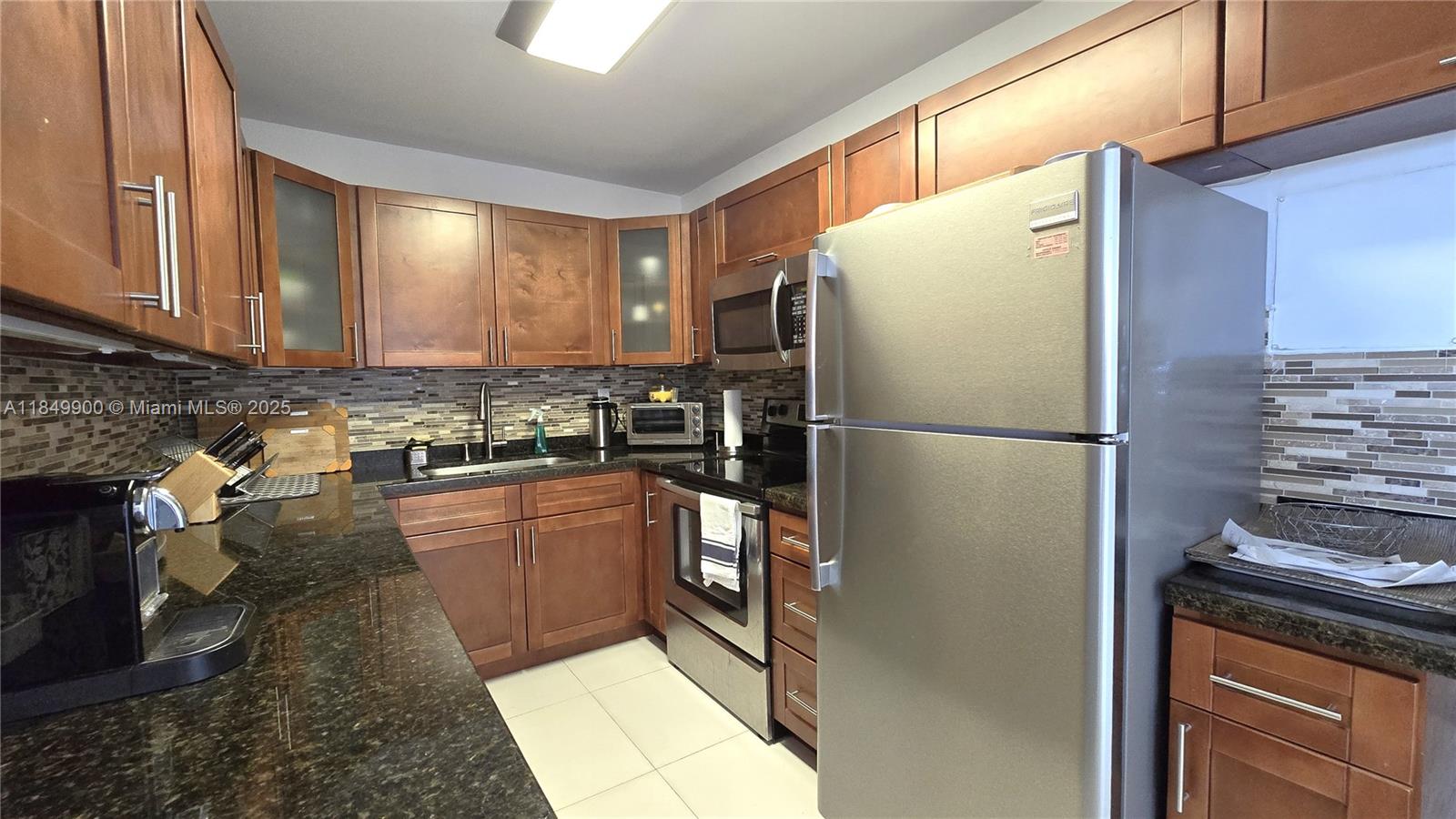 3731 North Country Club Drive, Unit 1825 Aventura, FL 33180 - Photo 8 of 25 a kitchen with stainless steel appliances granite countertop a refrigerator a stove and a sink