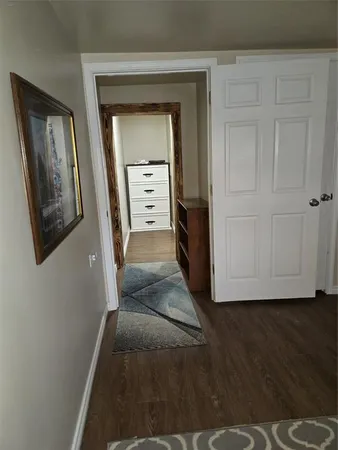 a view of a hallway with wooden floor and closet