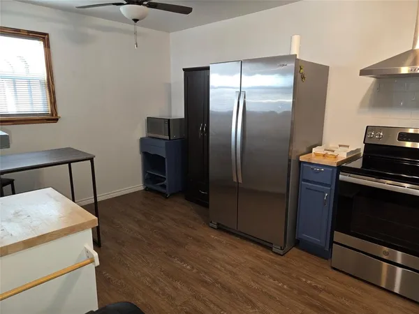 a kitchen with a refrigerator and a stove top oven