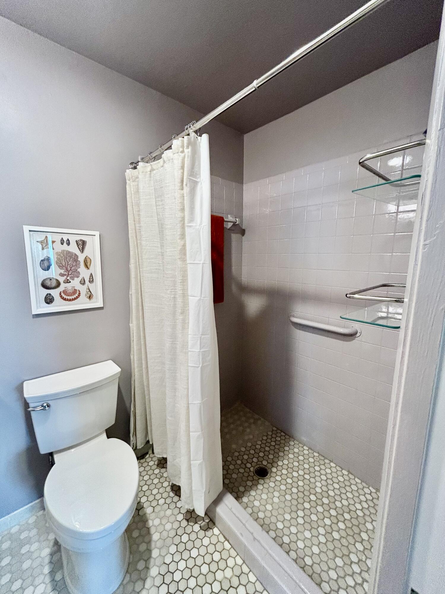 5289 Lake Front Boulevard, Unit D Delray Beach, FL 33484 - Photo 11 of 14 a bathroom with a toilet and a shower