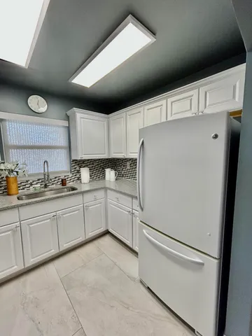 a white refrigerator freezer sitting inside of a kitchen