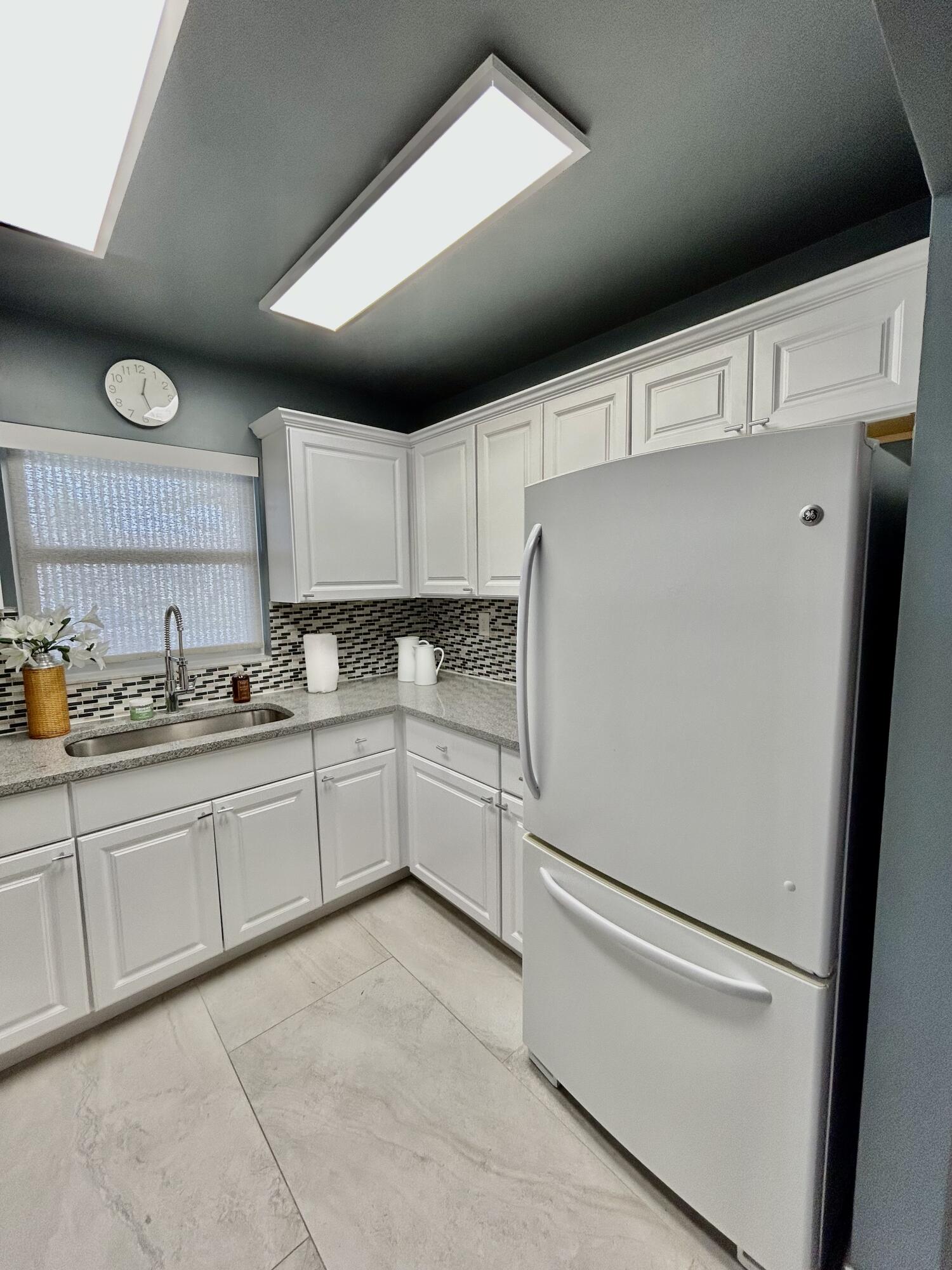 5289 Lake Front Boulevard, Unit D Delray Beach, FL 33484 - Photo 3 of 14 a white refrigerator freezer sitting inside of a kitchen