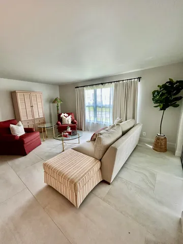 a bedroom with a large bed chandelier and a window