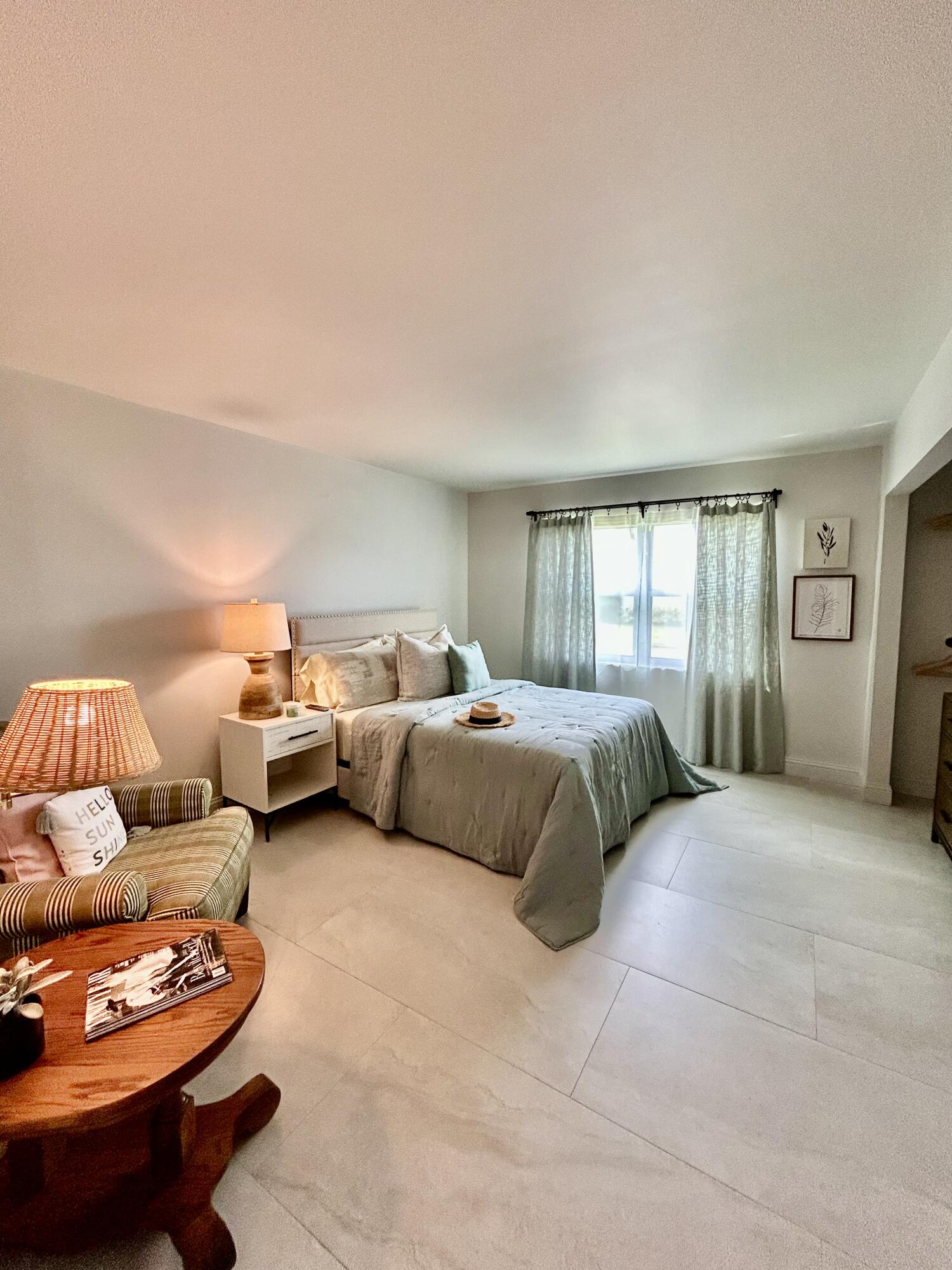 5289 Lake Front Boulevard, Unit D Delray Beach, FL 33484 - Photo 9 of 14 a bedroom with furniture and a couch