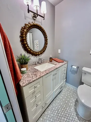 a bathroom with a granite countertop sink and mirror