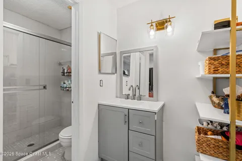 a bathroom with a shower sink and mirror