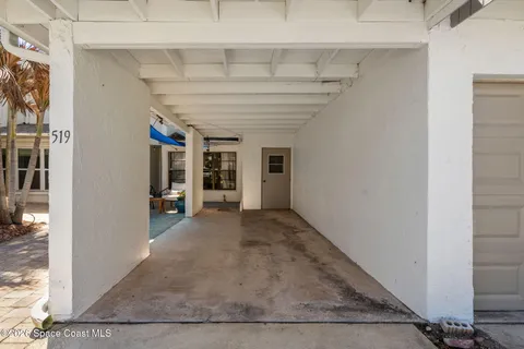 a view of a hallway with wooden floor and a living room
