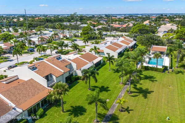an aerial view of residential houses with outdoor space and trees
