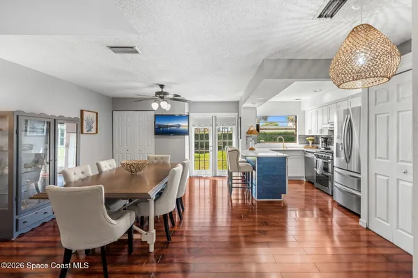 a dining room with furniture a chandelier and wooden floor