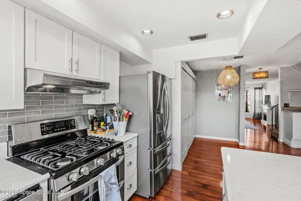 a kitchen with stainless steel appliances granite countertop a stove and a refrigerator