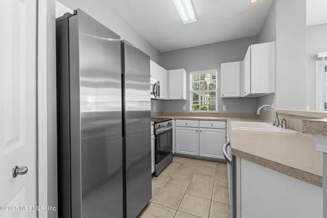 a kitchen with a refrigerator sink and cabinets