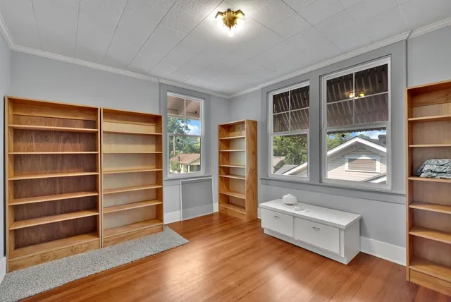 a living room with wooden floor and a window