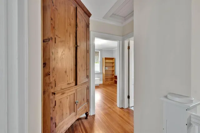 a view of a hallway with wooden floor and staircase